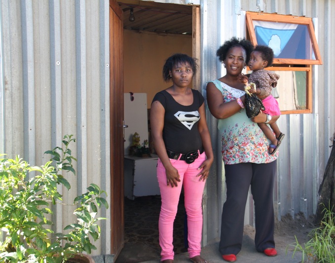 Pumza with Andiswa and her daughter in front of their new home